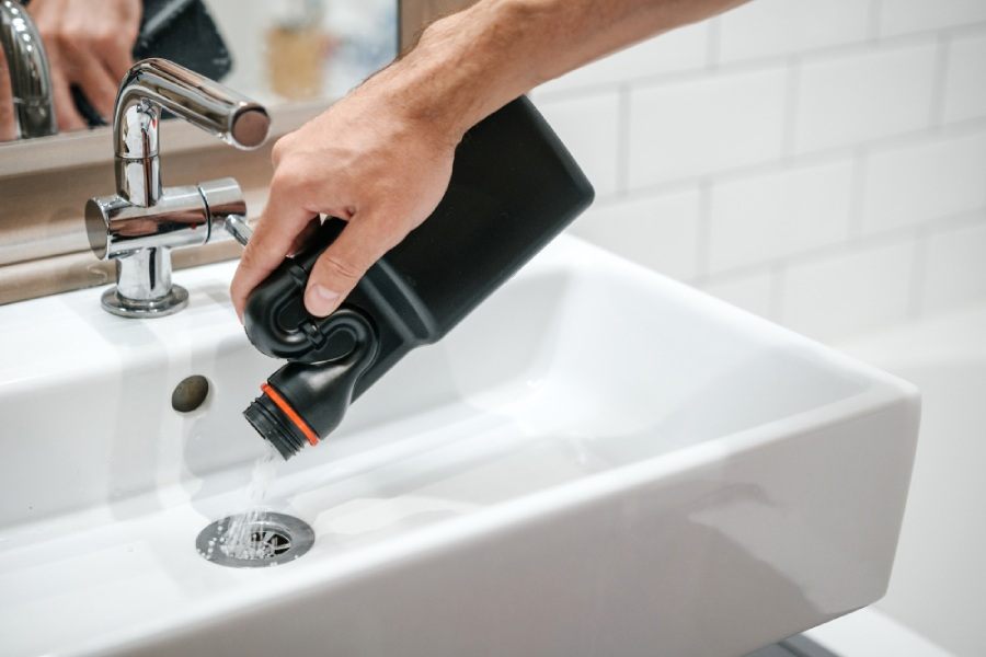 Man pouring drain cleaner in his sink